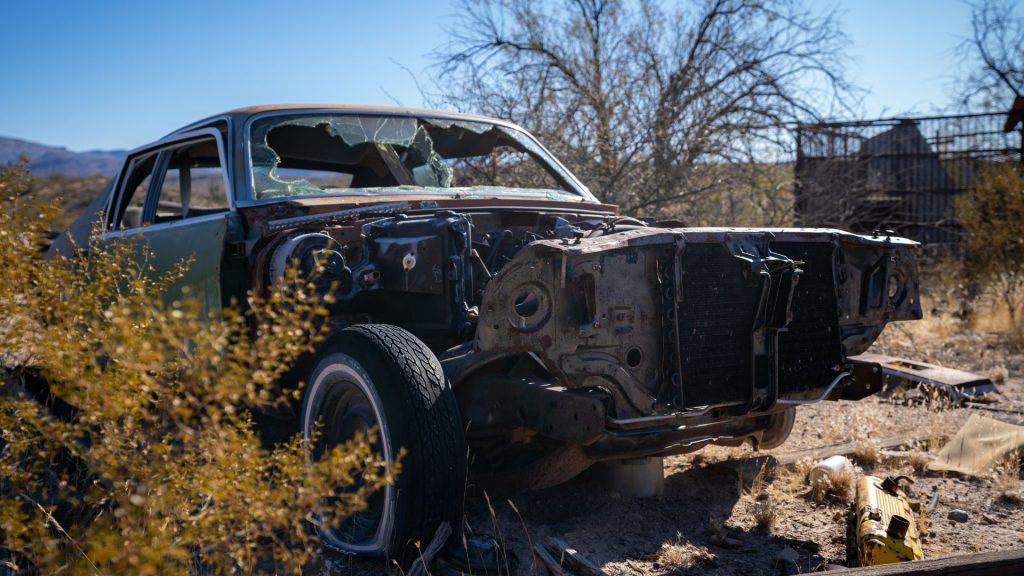 destroyed junk car in a dry land